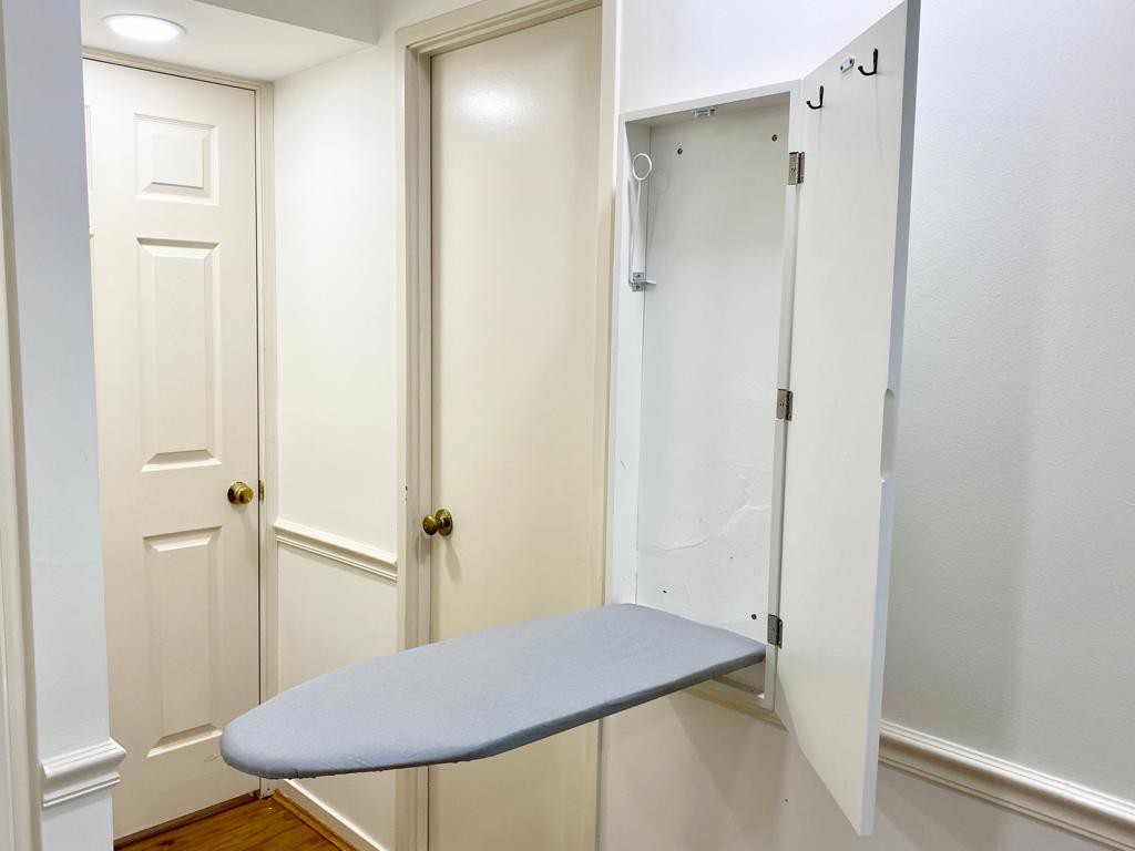 Ironing board next to bathroom door 